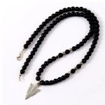 Descubre este exclusivo collar de cuentas de ónix negro combinado con un colgante punta de flecha fabricado en acero inoxidable: una pieza con estilo, carácter y significado.