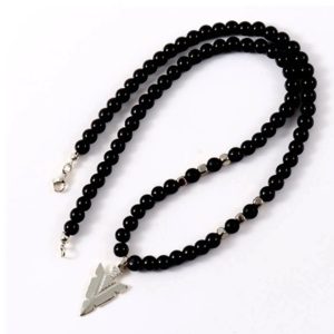 COLLAR DE CUENTAS DE ONIX Y COLGANTE DE FLECHA1 Descubre este exclusivo collar de cuentas de ónix negro combinado con un colgante punta de flecha fabricado en acero inoxidable: una pieza con estilo, carácter y significado.