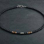 Collar elegante de ónix negro con 4 cuentas de ojo de tigre y cierre en acero inoxidable. Diseño unisex ideal para estilo diario o como regalo significativo.
