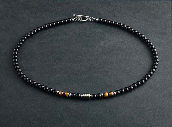 Collar elegante de ónix negro con 4 cuentas de ojo de tigre y cierre en acero inoxidable. Diseño unisex ideal para estilo diario o como regalo significativo.