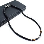 Collar elegante de ónix negro con 4 cuentas de ojo de tigre y cierre en acero inoxidable. Diseño unisex ideal para estilo diario o como regalo significativo.