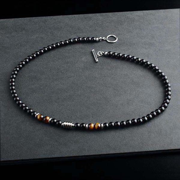 Collar elegante de ónix negro con 4 cuentas de ojo de tigre y cierre en acero inoxidable. Diseño unisex ideal para estilo diario o como regalo significativo.