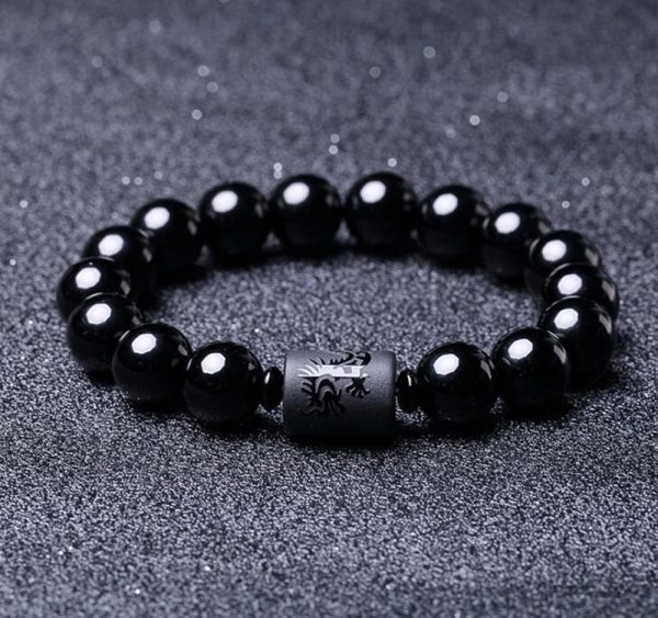 Fortalece tu energía y eleva tu presencia con esta imponente Pulsera de Ónix Negro, adornada con un cilindro grabado con un dragón, símbolo de poder, fuerza, liderazgo y buena fortuna en la cultura oriental.