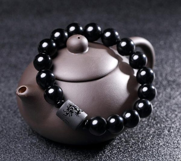 Fortalece tu energía y eleva tu presencia con esta imponente Pulsera de Ónix Negro, adornada con un cilindro grabado con un dragón, símbolo de poder, fuerza, liderazgo y buena fortuna en la cultura oriental.
