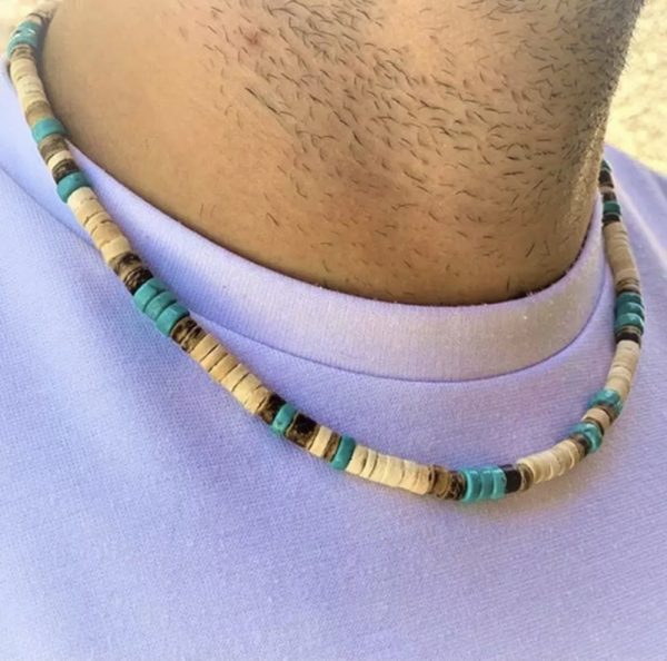 Añade un toque playero a tu look con nuestro collar surfista hecho a mano con cuentas de coco y cerámica. Perfecto para verano y espíritu libre.