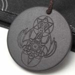 Este exclusivo collar de shunguita con grabado de ángel y símbolos sagrados no es solo un accesorio… es un amuleto de conexión, protección y energía personal.