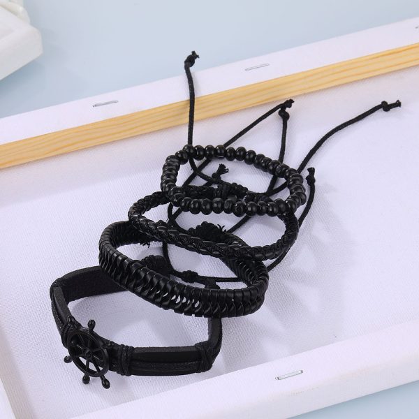 Este set de pulseras negras estilo náutico combina cuero trenzado, cuentas y un detalle central de timón que simboliza dirección, liderazgo