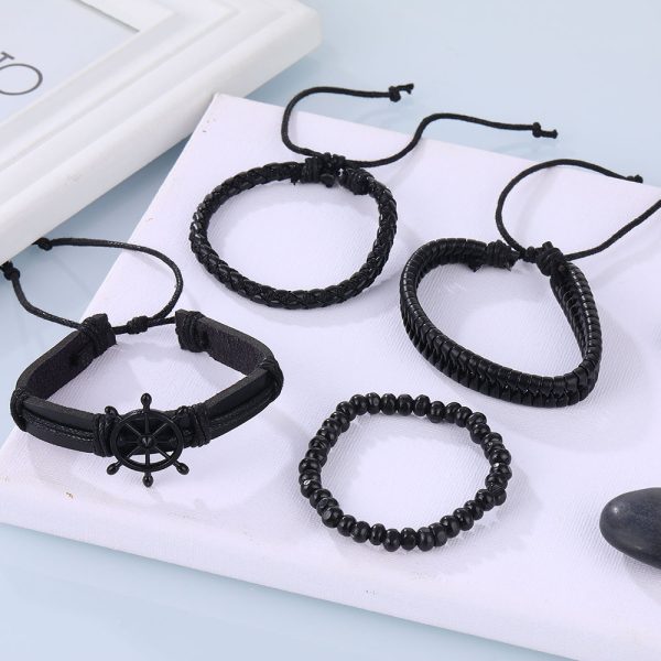 Este set de pulseras negras estilo náutico combina cuero trenzado, cuentas y un detalle central de timón que simboliza dirección, liderazgo