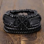 Este set de pulseras negras estilo náutico combina cuero trenzado, cuentas y un detalle central de timón que simboliza dirección, liderazgo