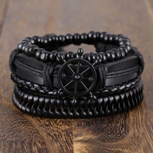 Este set de pulseras negras estilo náutico combina cuero trenzado, cuentas y un detalle central de timón que simboliza dirección, liderazgo