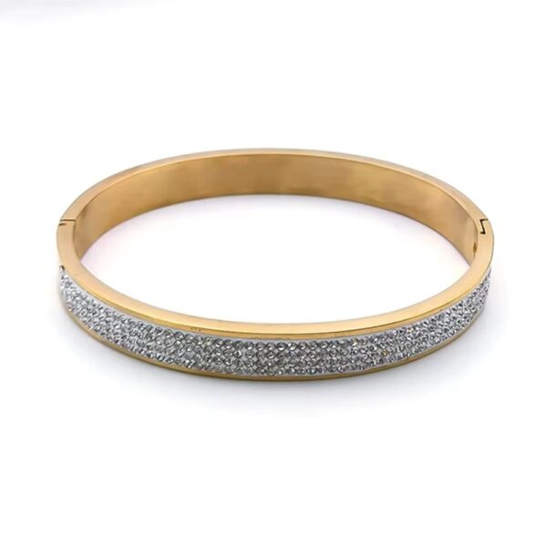 Inspirado en el lujo de la alta joyería, este brazalete combina la fuerza del acero inoxidable con un pavé de micro-cristales que capturan la luz desde cualquier ángulo, creando un efecto hipnótico que parece sacado de una constelación.