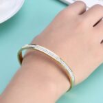 Inspirado en el lujo de la alta joyería, este brazalete combina la fuerza del acero inoxidable con un pavé de micro-cristales que capturan la luz desde cualquier ángulo, creando un efecto hipnótico que parece sacado de una constelación.