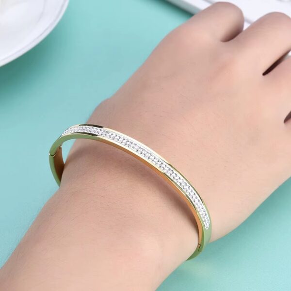 Inspirado en el lujo de la alta joyería, este brazalete combina la fuerza del acero inoxidable con un pavé de micro-cristales que capturan la luz desde cualquier ángulo, creando un efecto hipnótico que parece sacado de una constelación.