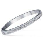 Inspirado en el lujo de la alta joyería, este brazalete combina la fuerza del acero inoxidable con un pavé de micro-cristales que capturan la luz desde cualquier ángulo, creando un efecto hipnótico que parece sacado de una constelación.