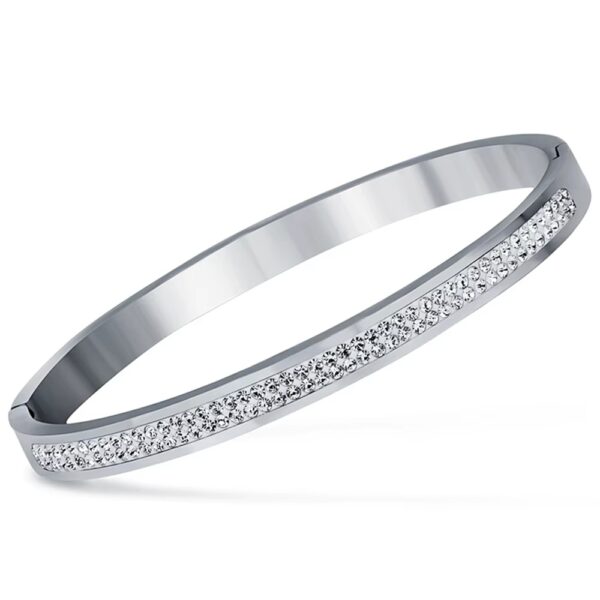 Inspirado en el lujo de la alta joyería, este brazalete combina la fuerza del acero inoxidable con un pavé de micro-cristales que capturan la luz desde cualquier ángulo, creando un efecto hipnótico que parece sacado de una constelación.